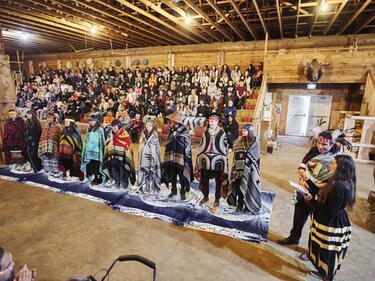2024 Role Models standing in front of a filled longhouse for the role model honouring ceremony.