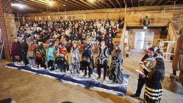 2024 Indigenous Role Model Honouring 2024 Role Models standing in front of a filled longhouse for the role model honouring ceremony.