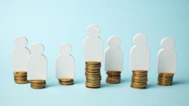 Figures of people on stacks of coins. Different levels of people's earnings