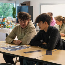 Two male students sitting at a table working on a task