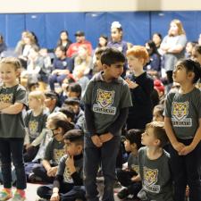 A few students standing up during an assembly to acknowledge their birthdays