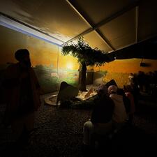 Highschool students gathered together in a dark room with minimal light at their field trip to Gobind Sarvar
